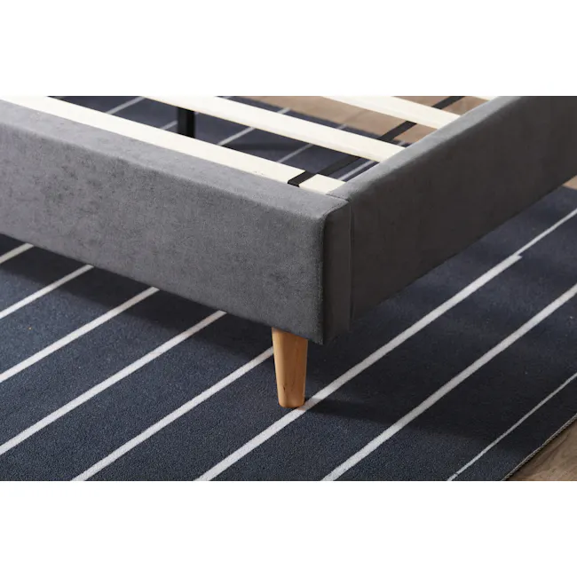 Nolan Queen Bed - Hailstorm - 12 - Gray upholstered sofa with wooden legs, dark blue and white striped rug, modern design