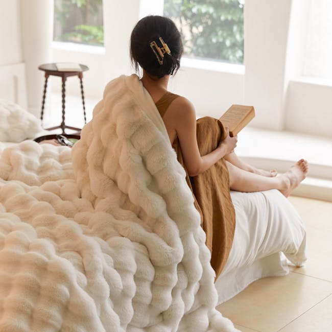 Jaclyn Luxe Plush Throw Blanket in White (2 sizes) - 3 - Soft, fluffy white and brown blanket, woman reading book, cozy