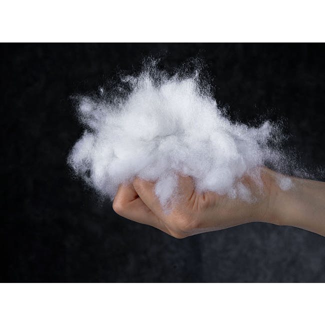 Dainie Textured Puffed Grid Lumbar Cushion - Black - 10 - Hand holding fluffy white cotton, dark background, close-up view