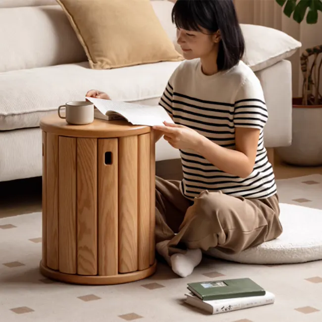 Coree Stackable Stool Set / Side Table - Oak - 16 - Sitting on a cushion, reading a book, wearing a striped shirt, sitting