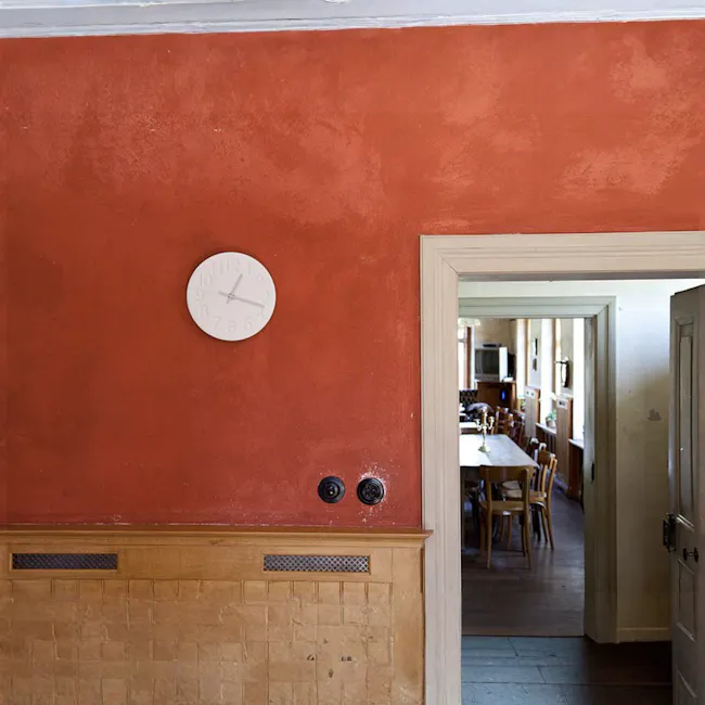 Keisoudo no Tokei Wall Clock - White - 2 - Red textured wall, white clock, wooden paneling, two black knobs, dining room