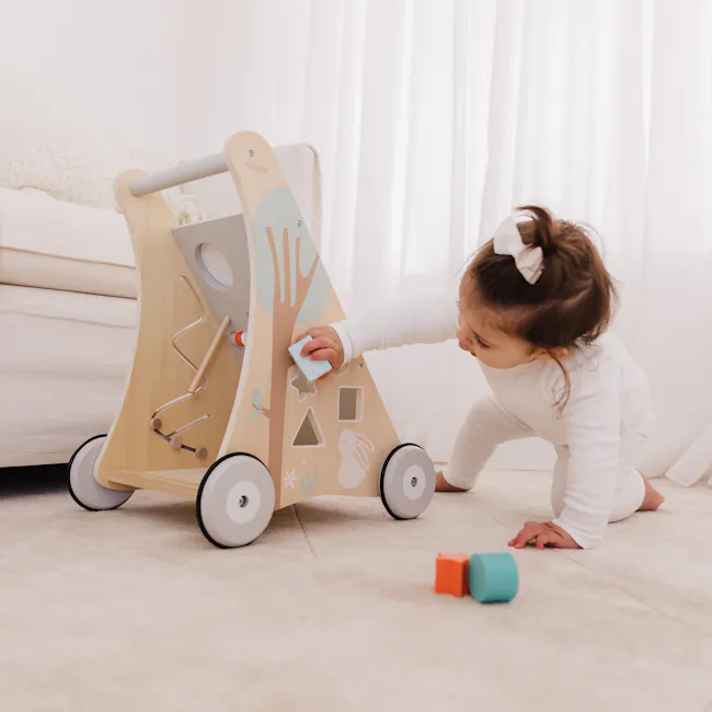 Bubble Wooden Activity Play Walker - 9 - Wooden play gym with colorful designs, child playing with toy, white curtains in