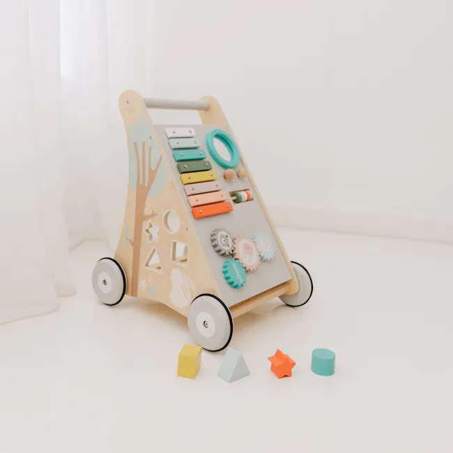 Bubble Wooden Activity Play Walker - 2 - Wooden playset with colorful toys, including blocks, gears, and stars, set against