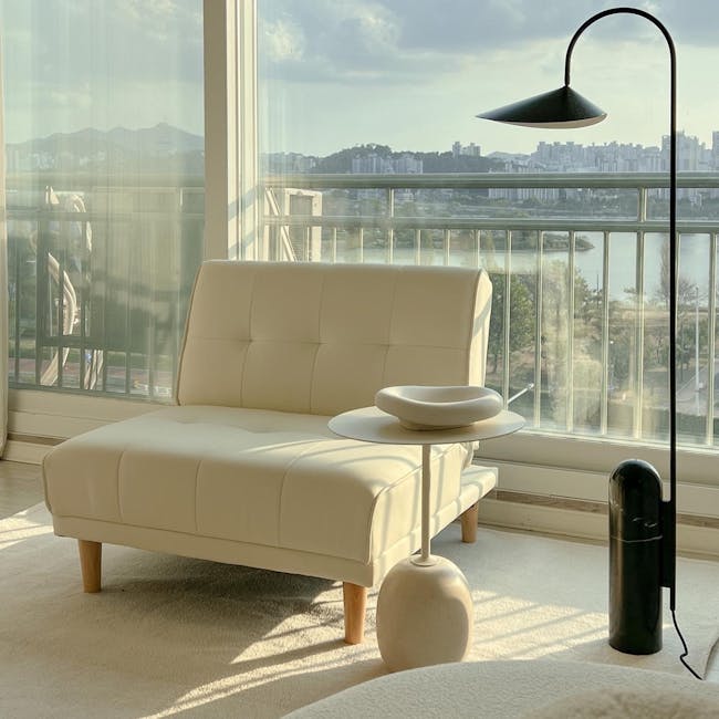 Candice 1 Seater Sofa Bed - Ivory (Faux Leather) - 13 - Luxurious beige sofa, modern floor lamp, cityscape view, large