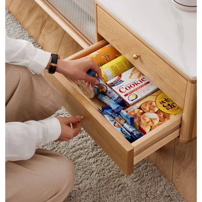 Aster TV Console 2m - Oak (Sintered Stone) - 7 - White shirt, beige pants, wooden drawer, person, kneeling, open drawer