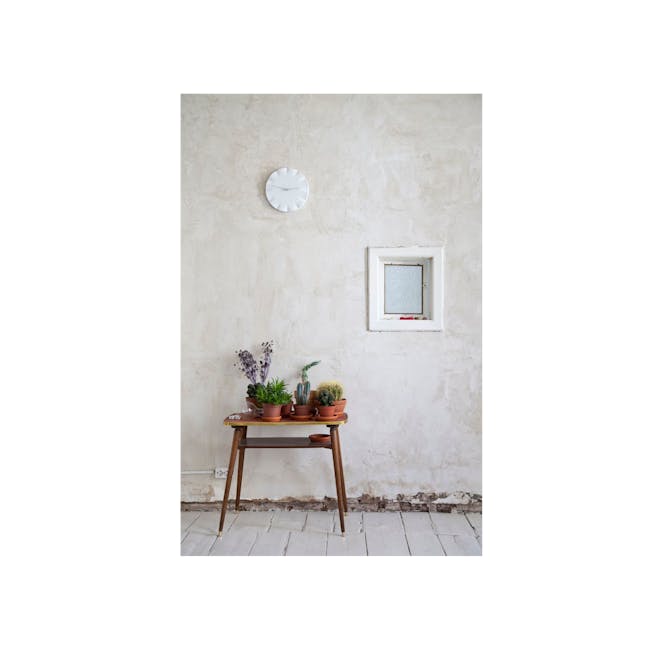 Kifuku Clock - 2 - White textured wall, rustic charm, minimalist decor, wooden table, potted plants, natural light