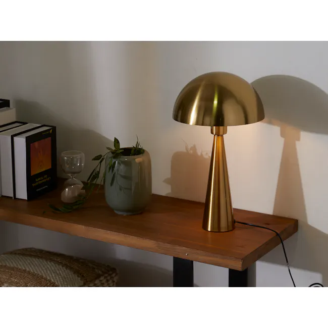 Cohen Table Lamp - Brass - 2 - Golden desk lamp, book titled "The Unconventional Bible, " green vase with leaves, hourglass