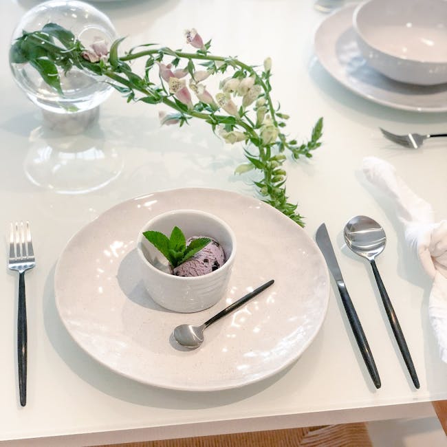 Stanley Rogers Piper Black 16Pc Cutlery Set - 2 - Clear glass sphere, delicate flowers, white plate, elegant dining setup