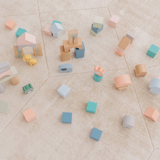 Bubble Wooden Activity Blocks - 4 - Soft pastel-colored wooden blocks scattered on a textured carpet, featuring various