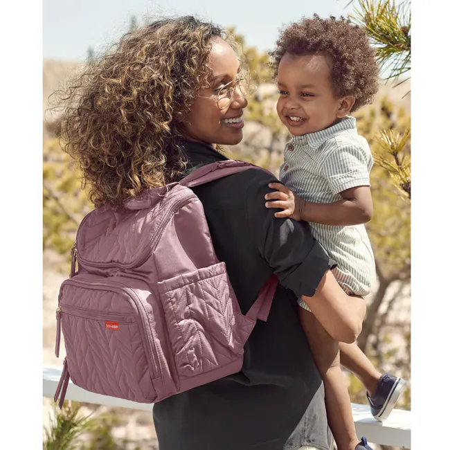 Skip Hop Forma Nappy Backpack - Mauve Mist - 9 - Curly hair, glasses, smiling woman, child, outdoor setting, backpack