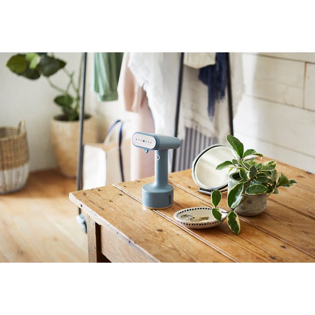 BRUNO Styling Handy Steamer - Mint Green - 6 - blue desk lamp, wooden table, potted plant, white wall, natural light, rustic