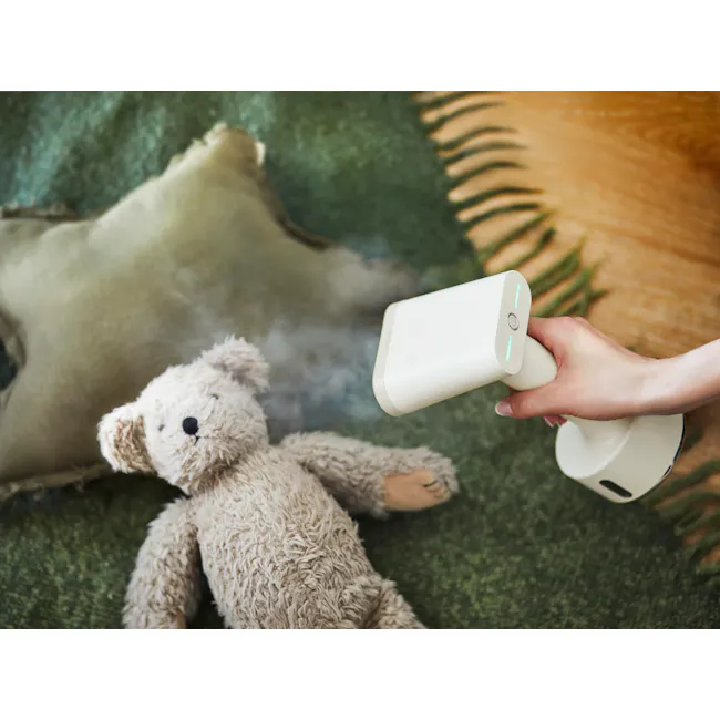 BRUNO Styling Handy Steamer - Mint Green - 4 - White humidifier, fluffy teddy bear, green carpet, hand holding humidifier