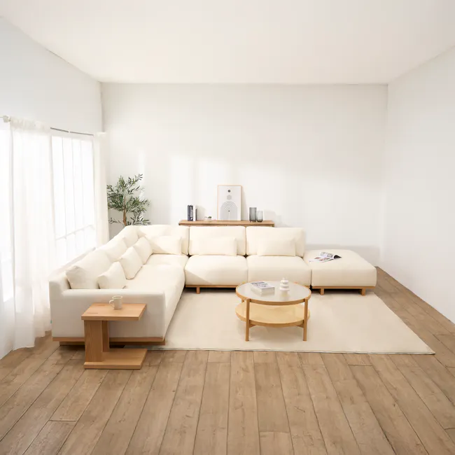 Miu Side Ottoman - 5 - Minimalist living room with white walls and ceiling, large beige sectional sofa, wooden coffee table