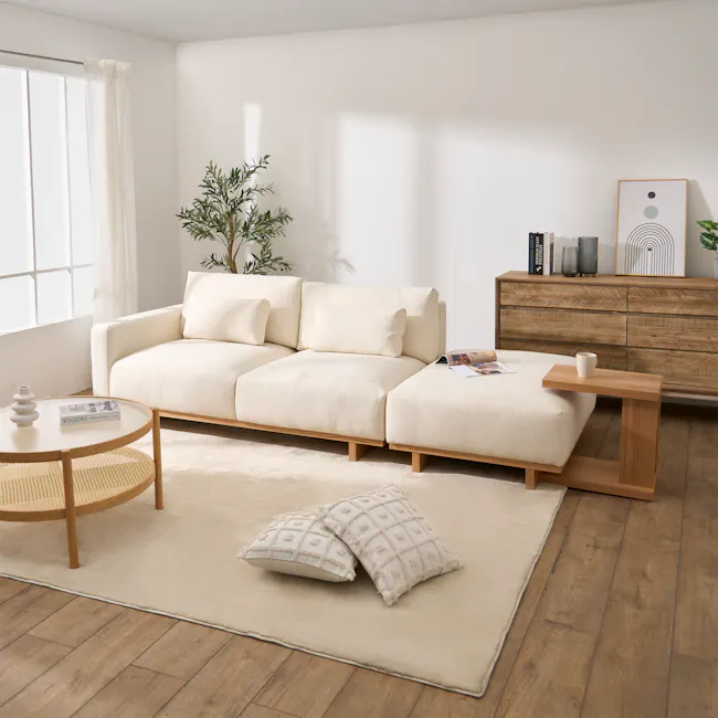 Miu Side Ottoman - 3 - Minimalist living room with beige sectional sofa, natural light streaming through window, wooden