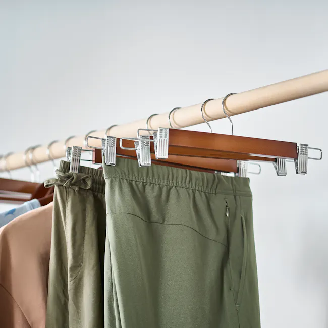 Wooden Clip Hanger - Walnut (Set of 10) - 2 - Hanging green pants on wooden hanger, metallic clothespins, neutral