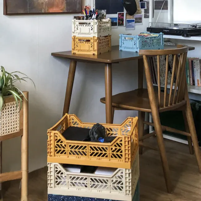 Aykasa Foldable Midibox - Boulder - 13 - Wooden table, colorful crates, indoor setting, plant, wooden chair, bookshelf