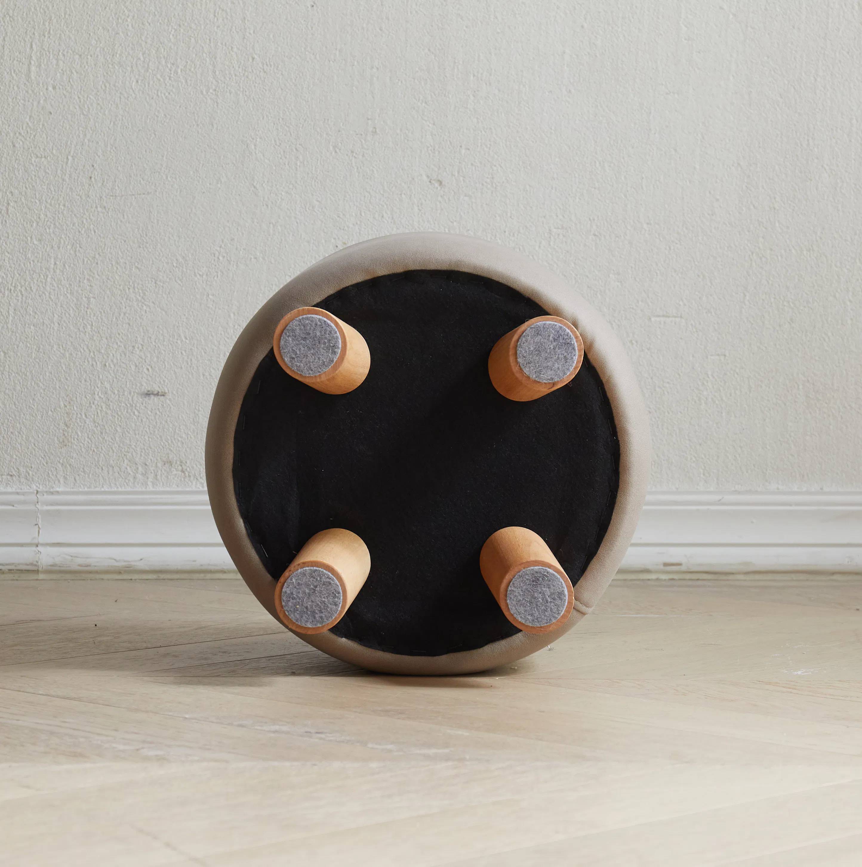 Niyo Stool - Tan - 13 - Round ottoman with four cylindrical wooden handles, beige cushioned interior, black fabric exterior