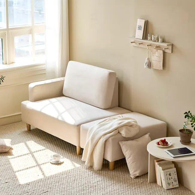 Genevieve 2 Seater Chaise Sofa with Ottoman - Ivory (Pet Friendly) - 10 - Sunlit beige sofa, cozy armchair, soft throw