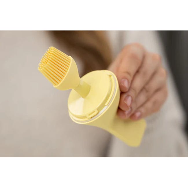 Zuutii Oil Dispenser with Brush - Light Cream - 5 - Yellow toothbrush holder, handheld toothbrush, close-up view, person