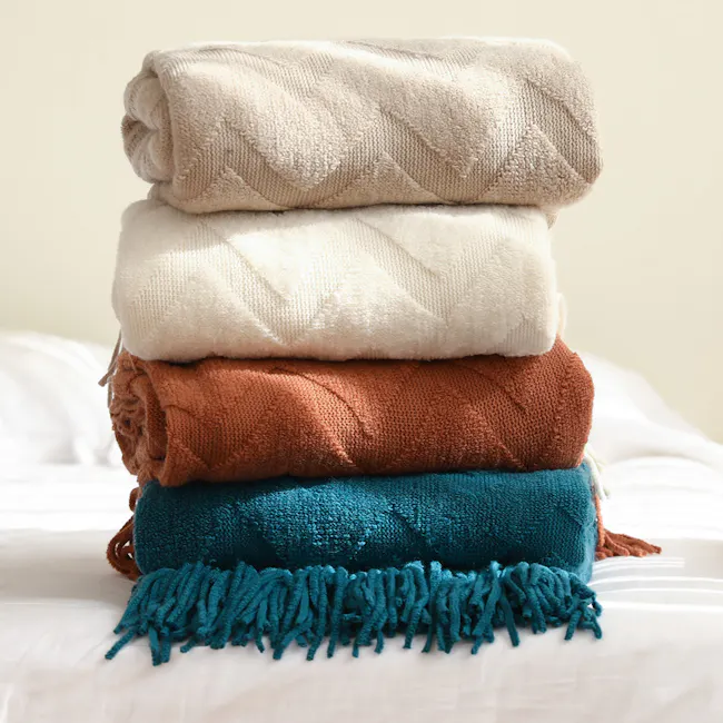 Hikari Chevron Knitted Throw - Off White - 3 - Soft, cozy blankets stacked neatly, cream, white, brown, teal, fringed edges