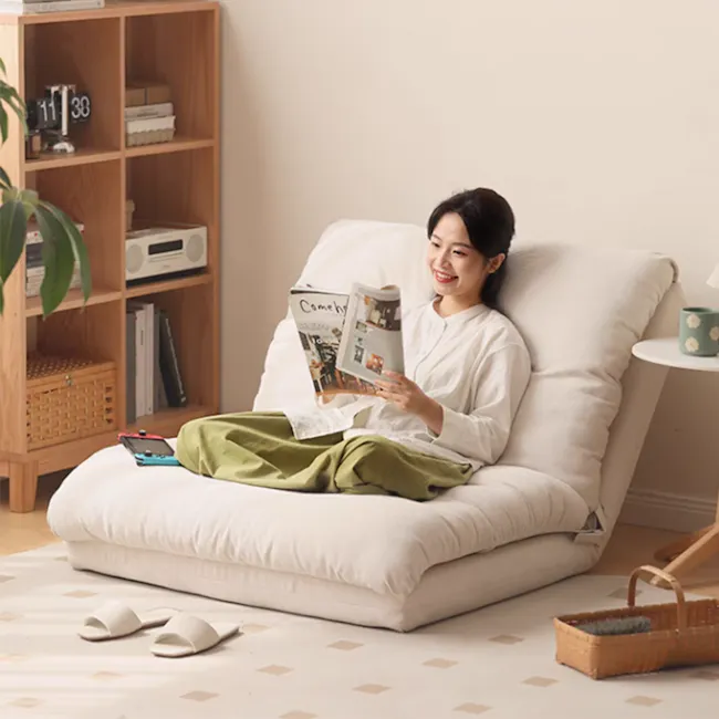 Jesse Sofa Bed - Cream Corduroy - 11 - Lovingly reading a magazine, woman comfortably lounging on a cushioned chair, cozy