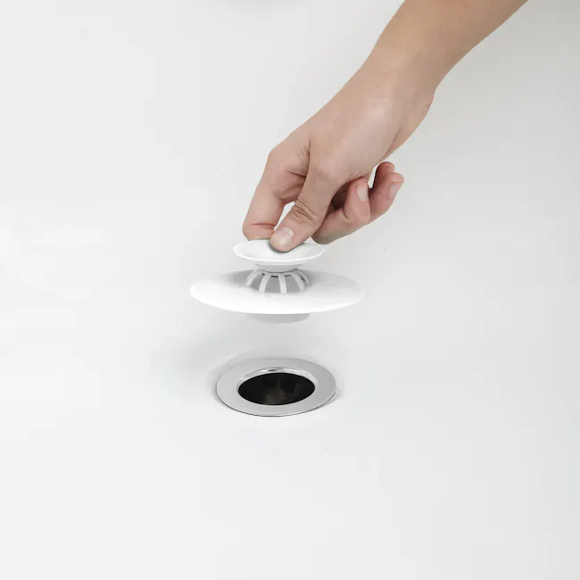 Flex Drain Stop/Hair Catcher - White - 4 - White sink, hand holding, toilet paper holder, toilet paper dispenser, modern