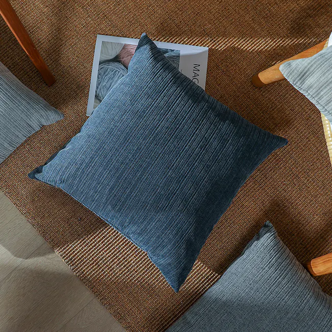 Minnesota Cushion - Light Grey - 4 - Blue textured pillows, wooden chair, woven rug, natural lighting, cozy atmosphere