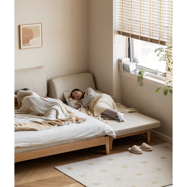 Zara Sofa Bed - Gravel White - 7 - Soft, cozy bedroom, beige and white bedding, person sleeping, window with blinds, indoor