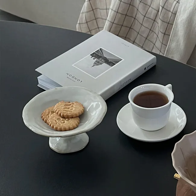 Seifer Coffee Table - 7 - White plate with biscuits, white cup of tea, book titled "London, " dark coffee, modern table