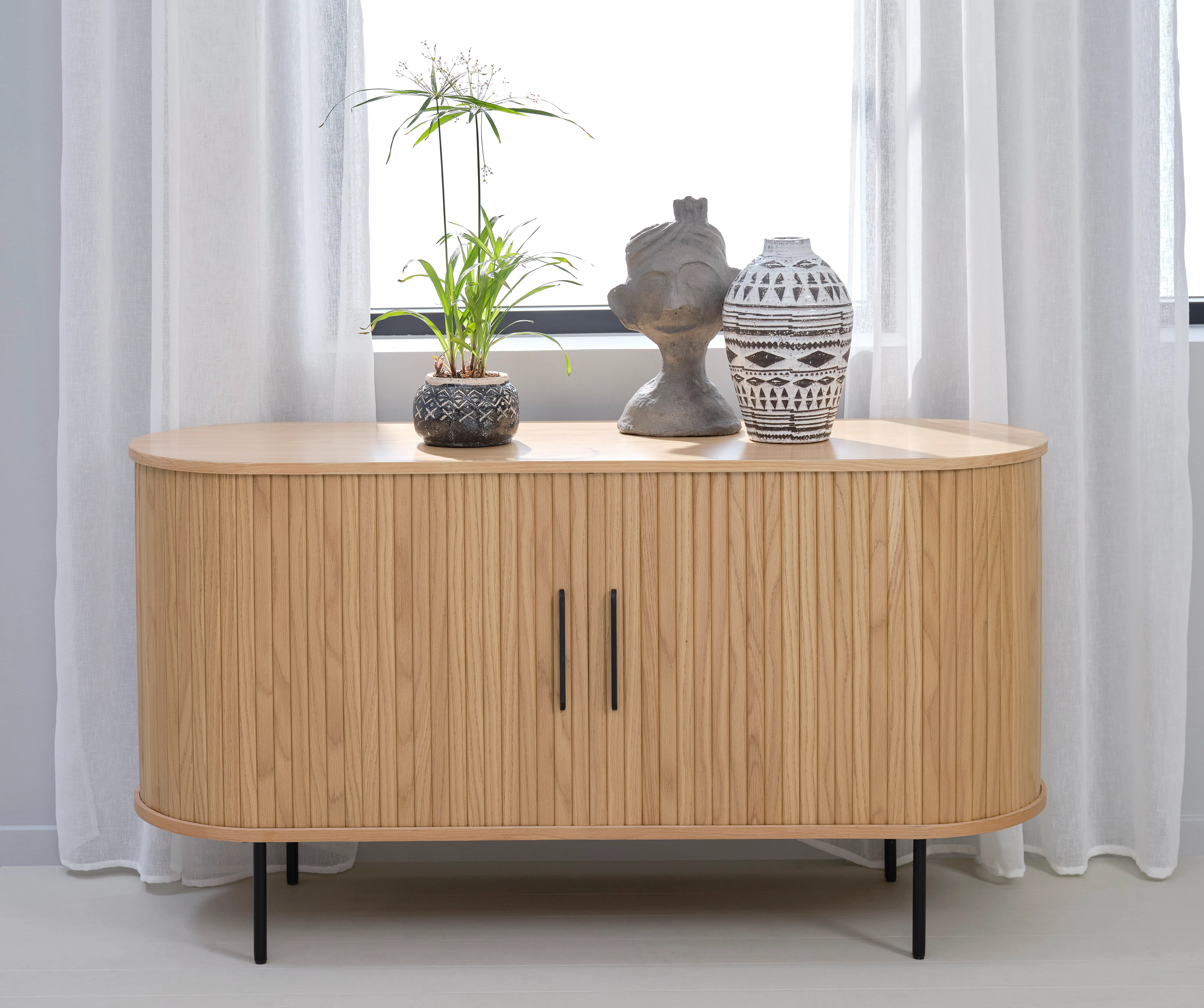 Nola Sideboard 1.4m - Oak - 10 - Light wood cabinet, minimalist design, round top, black metal legs, white curtains, indoor