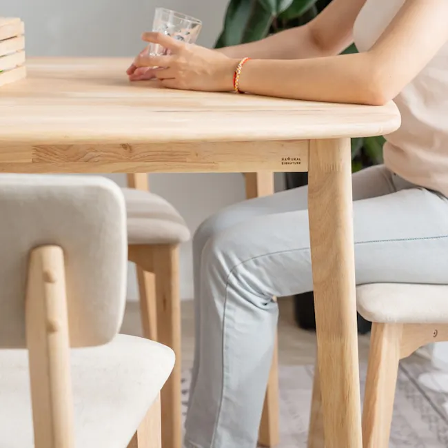 Hockey Chair - Grey - 9 - Light wooden table, minimalist design, natural wood finish, person sitting, light blue jeans