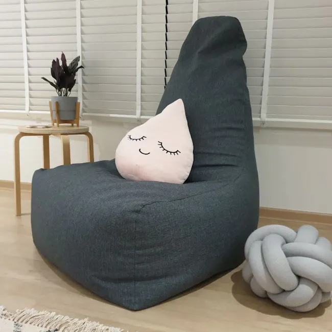 Milly Bean Bag - Teal - 2 - Grey upholstered lounge chair, plush pillow with closed eyes, cozy indoor setting, modern decor