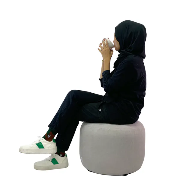March Ottoman - Brown - 9 - black hijab, gray ottoman, white mug, seated posture, casual attire, white sneakers, green
