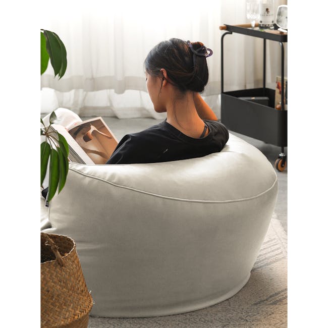 August Round Bean Bag - Rice White (Faux Leather) - 4 - Light gray bean bag chair, woman reading magazine, indoor setting