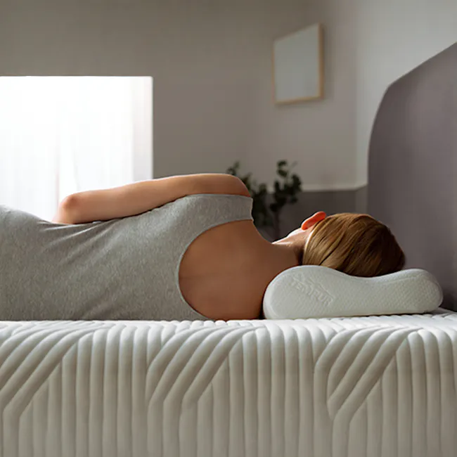 TEMPUR® Original Pillow (4 Sizes) - 2 - Woman sleeping on bed, wearing lace bra, white pillow, soft bedding, serene