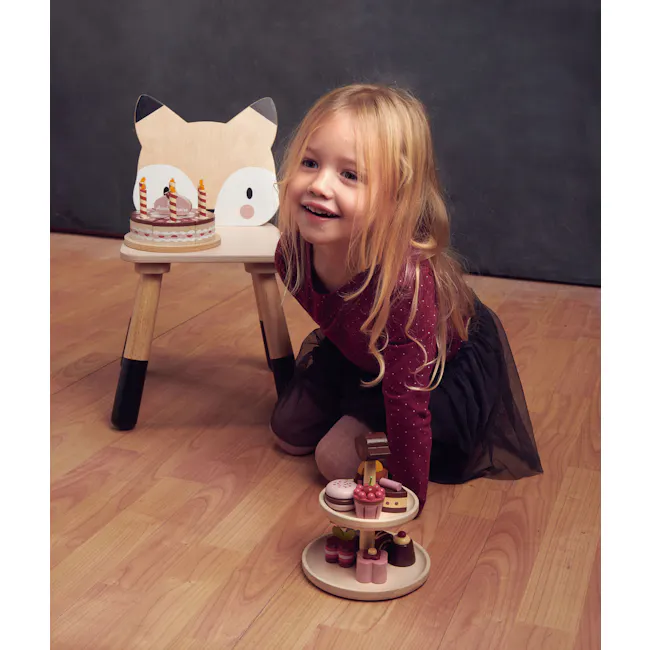 Tender Leaf Forest Chair - Fox - 4 - Cute girl with blonde hair, wearing a red dress, sitting on the floor, smiling, holding