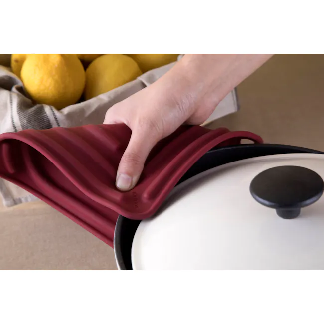 Cookduo Air Trivet - Red - 3 - Lemon, hand, red silicone, air fryer, black knob, white plate, beige background, yellow