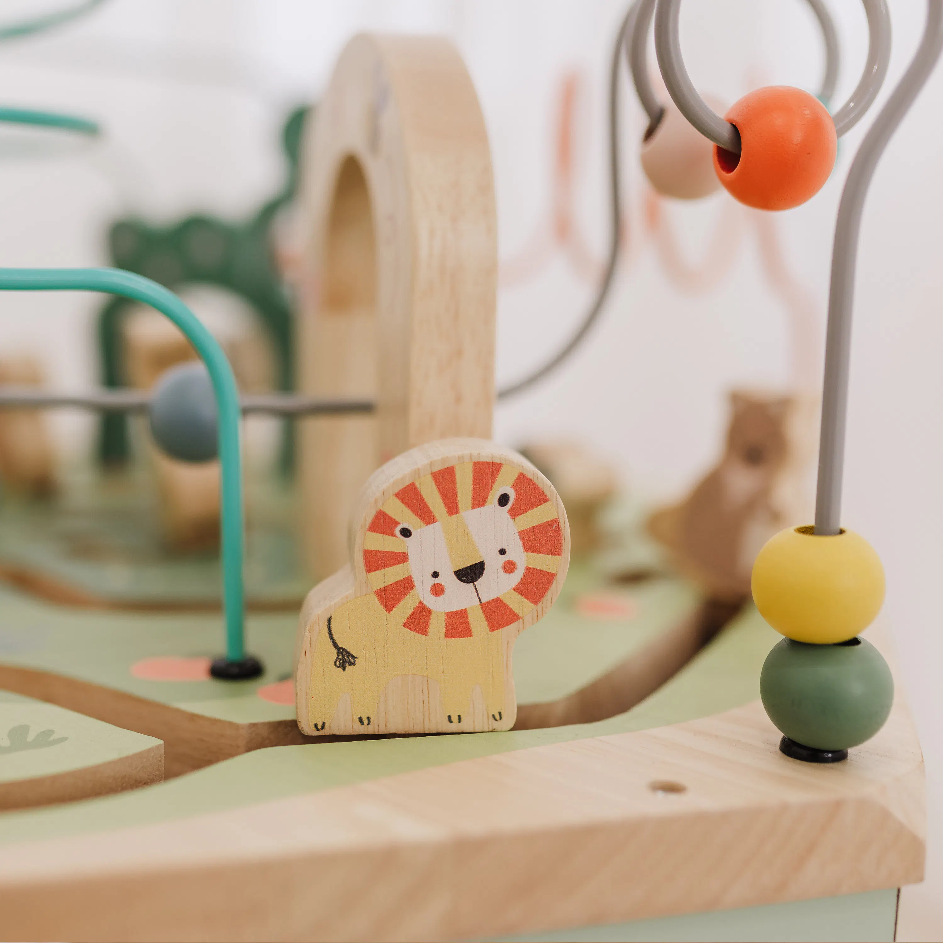 Bubble 7-in-1 Hexagon Wooden Activity Centre - 11 - Lion-shaped wooden toy with red, yellow, and orange patterns, placed on