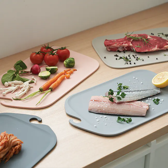 Modori Cutting Board - Warm Pink - 4 - Fresh vegetables on cutting board, salmon fillet on gray cutting board, lemon wedge