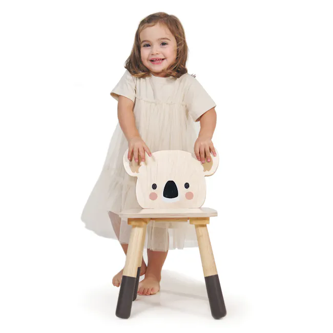 Tender Leaf Forest Chair - Koala - 4 - Cute young child, smiling, standing, barefoot, white dress, wooden koala toy, wooden