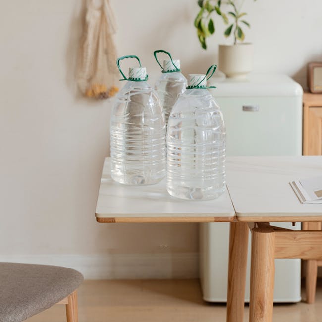 Fidela Extendable Dining Table 0.9m-1.5m (Sintered Stone) - 4 - Clear plastic water bottles, green handles, white walls