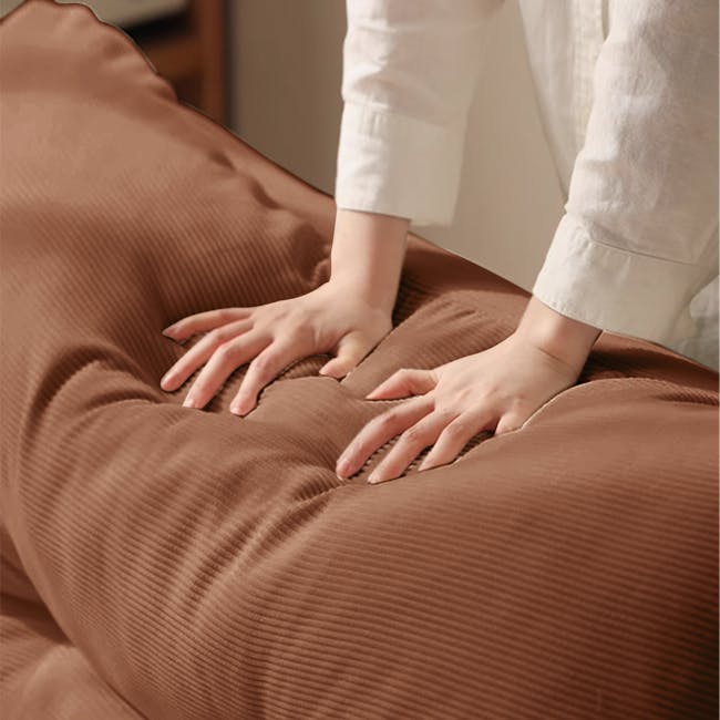 Jesse Sofa Bed - Brown Corduroy - 5 - Soft, brown, textured fabric, person's hands gently pressing, white shirt sleeves