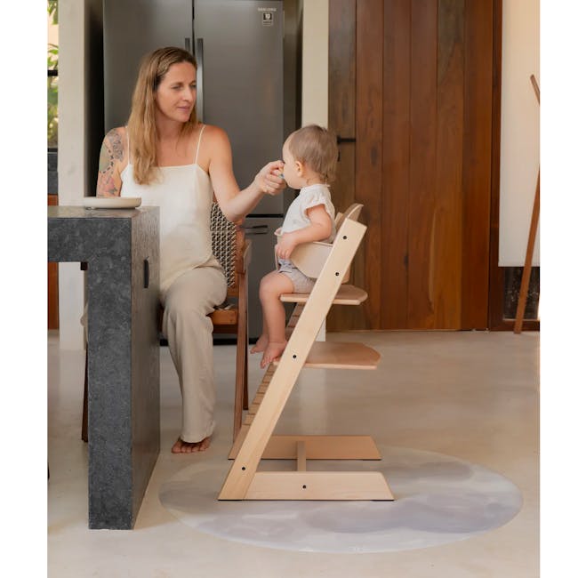 Toddlekind Prettier Round Splat Mat 1m - Clouds - 6 - Woman with tattoos, sitting at kitchen counter, feeding baby in high