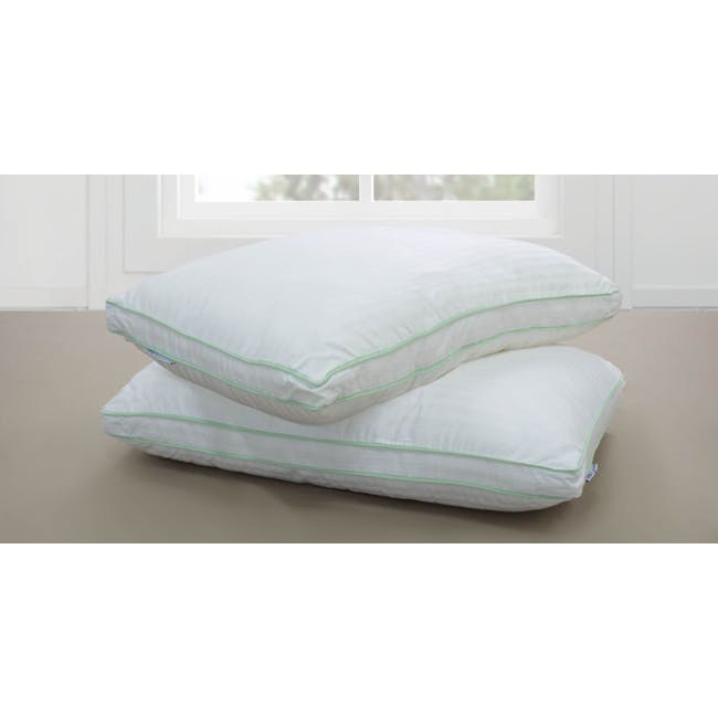 MaxCoil Panel Loft 7 Hole Fibre Fill Pillow - 2 - White pillows with green trim, neatly stacked bed, soft bedding