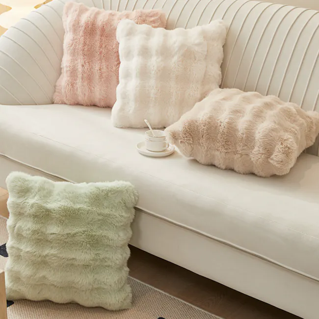 Luxe Faux Fur Cushion Cover - White - 7 - Soft, fluffy pillows in pastel colors sit on a white, ribbed sofa, accompanied by