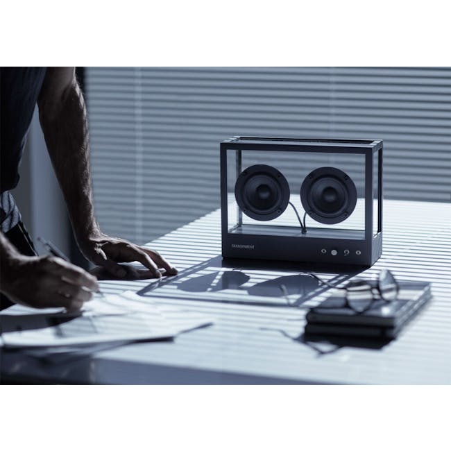 Small Transparent Speaker - Black - 2 - man writing on paper, glasses on table, transparent speaker box, indoor office