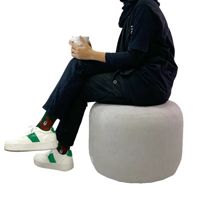 March Ottoman - Black - 4 - black hoodie, black pants, green and white sneakers, white mug, brown bear socks, gray ottoman