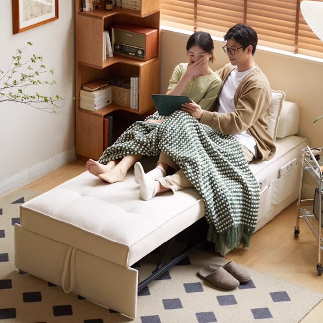 Tilly Lounge Sofa Bed - 4 - Sitting on a cozy sofa, couple sharing a tablet, green and white checkered blanket, indoor