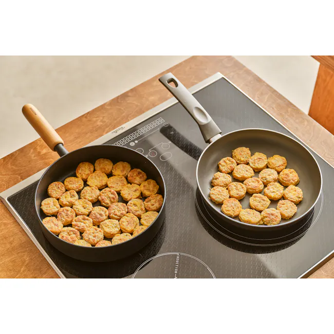 Goodle Nonstick Frying Pan 24cm - 5 - Fried patties cooking on induction cooktop, two frying pans with wooden handles