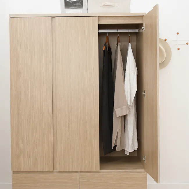 Firoh 3 Door Wardrobe with 2 Drawers - 7 - Light wood wardrobe, open doors, hanging clothes, beige and black garments, white